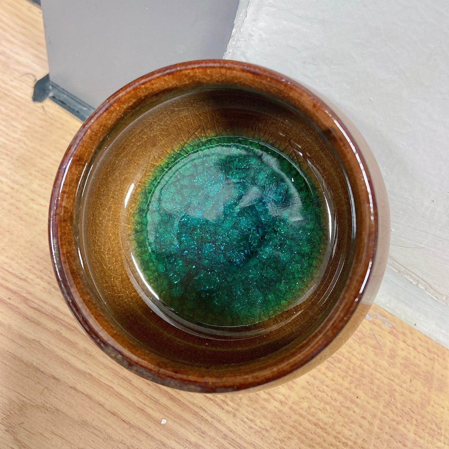 Saturn brown teacup with green crystal inside